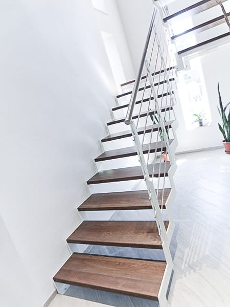 Walnut-stained beech zig zag staircase with white steel strings
